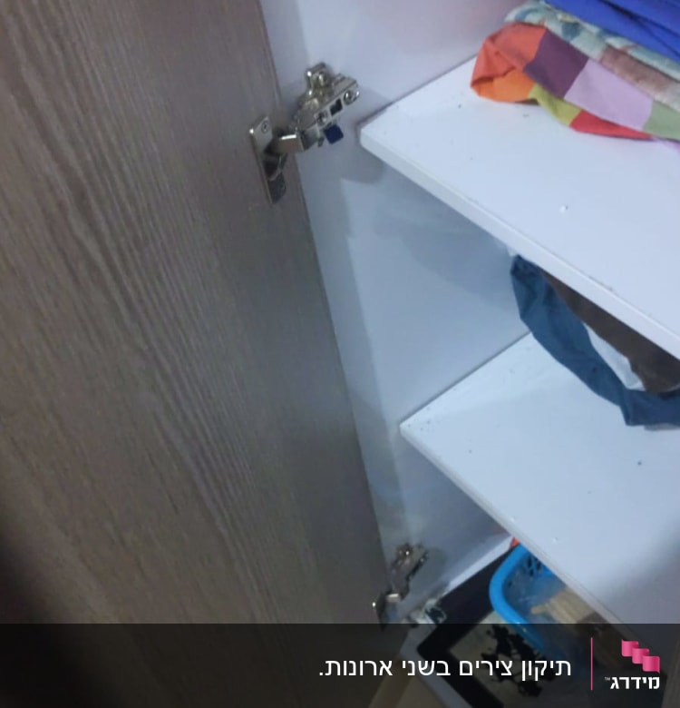 דלת ארון פתוחה עם צירים מתכתיים